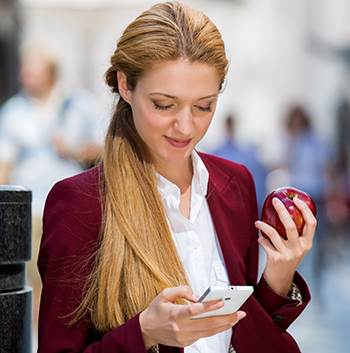 woman on phone holding apple