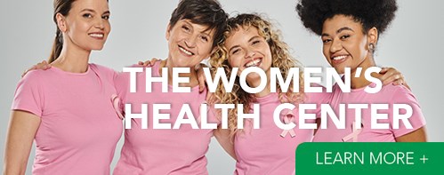 four women wearing pink shirts and breast cancer awareness ribbons